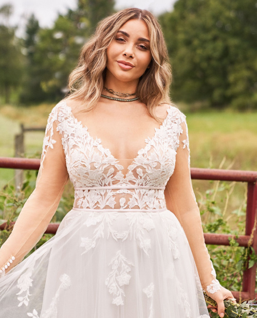 Beuatiful plus size model in a long sleeve boho style wedding dress with soft a-line skirt